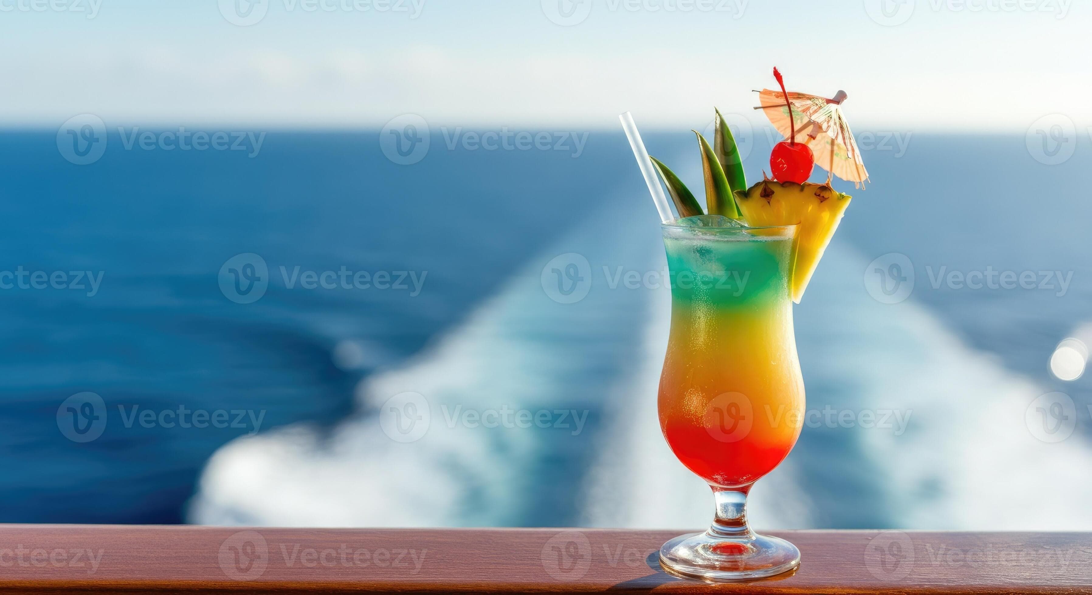 Colorful tropical cocktail with umbrella on cruise ship deck overlooking ocean wake