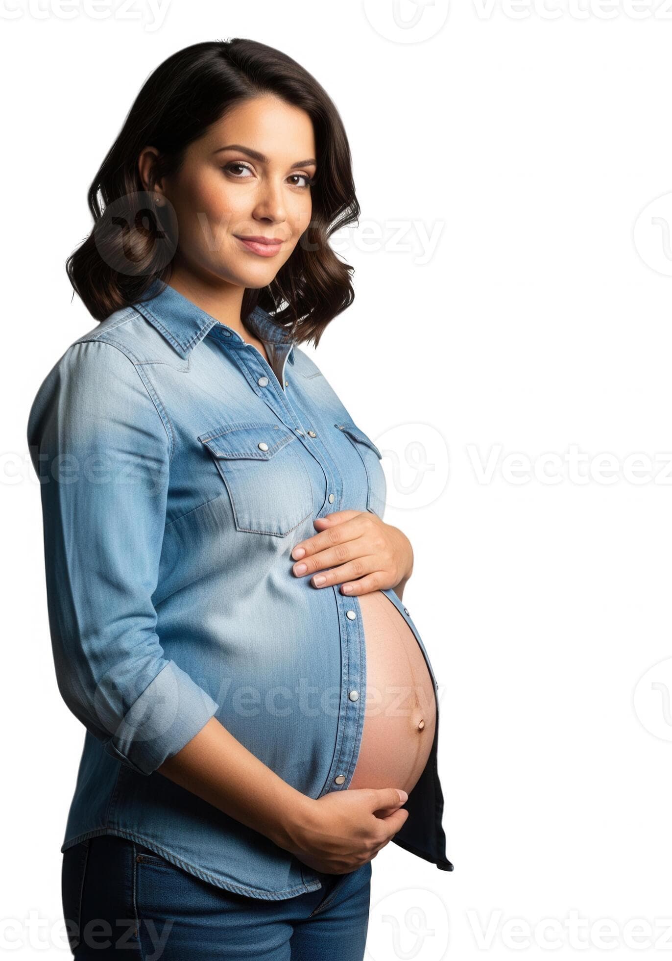 Pregnant woman with hands resting on her belly wearing a denim shirt.