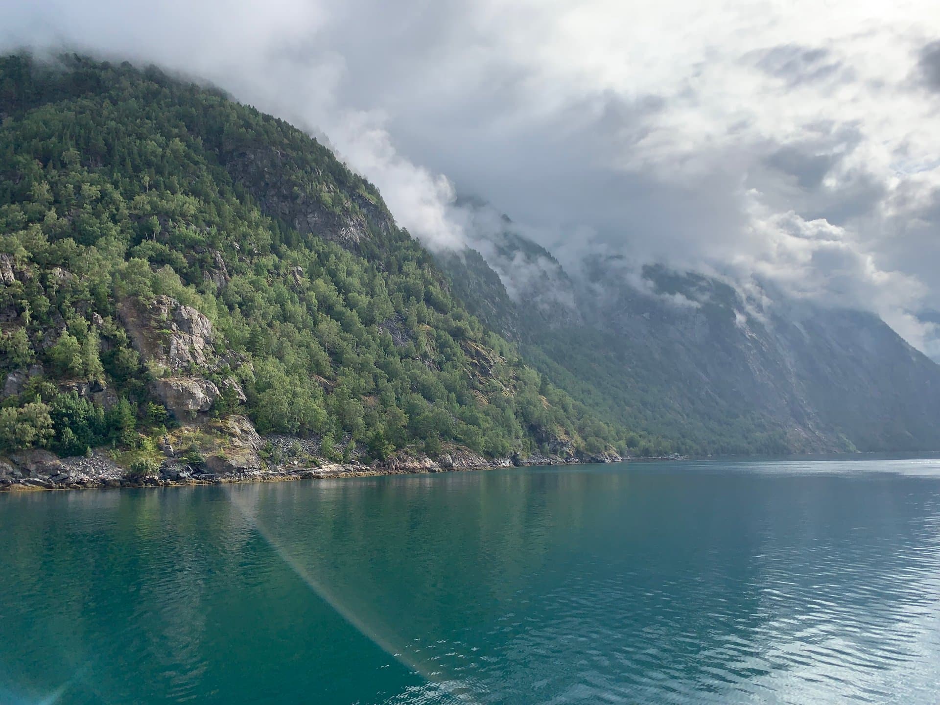A body of water surrounded by mountains and trees