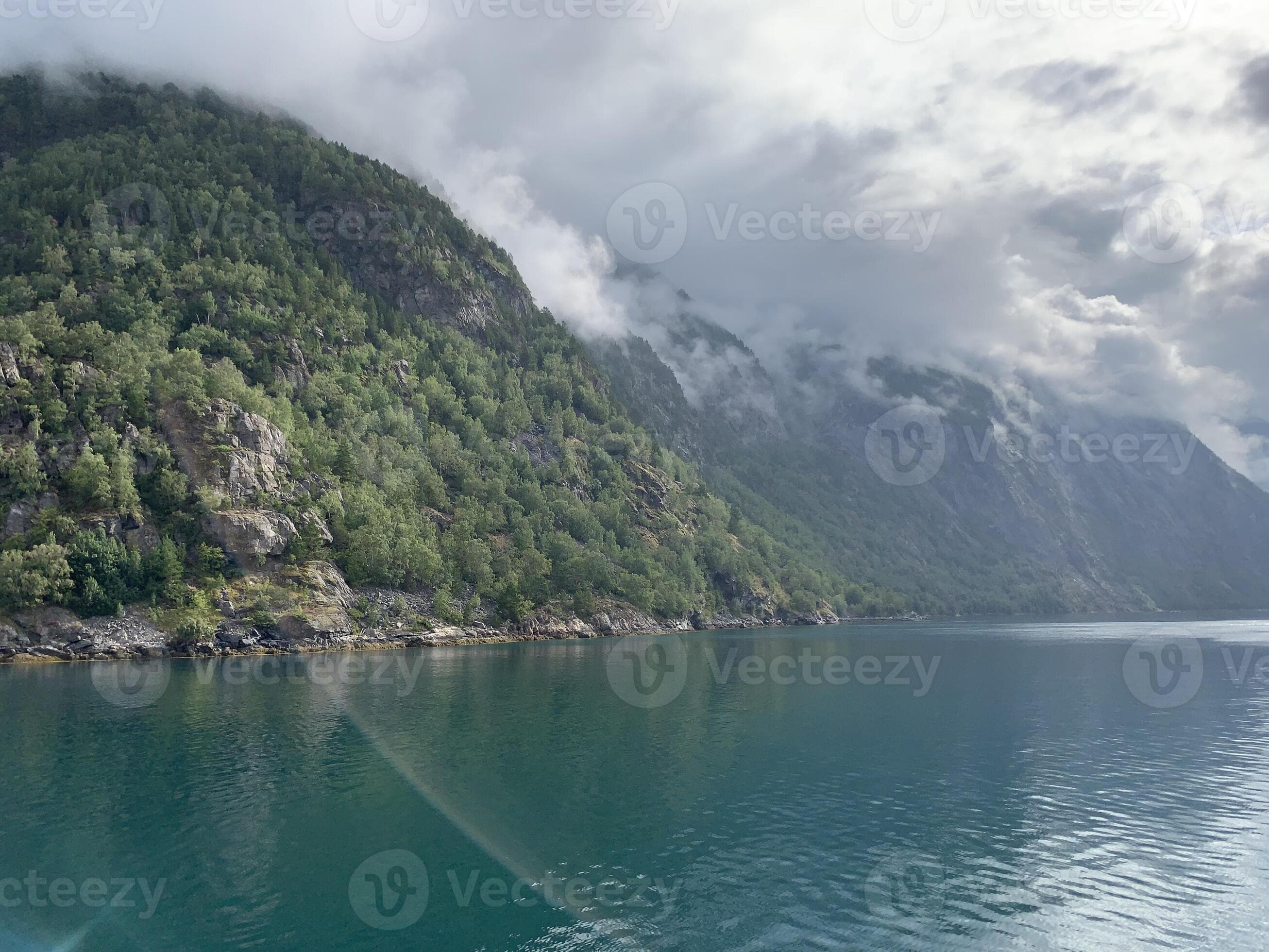 A body of water surrounded by mountains and trees